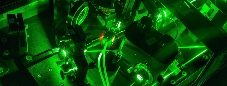 A detail shot of a laser in the lab in dark green colors.